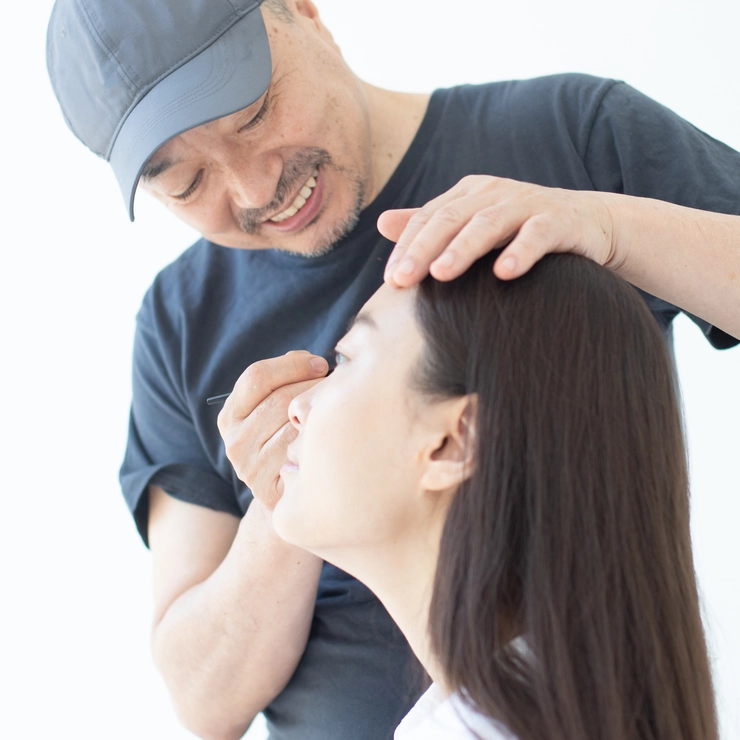 女性にメイクをする吉川さん