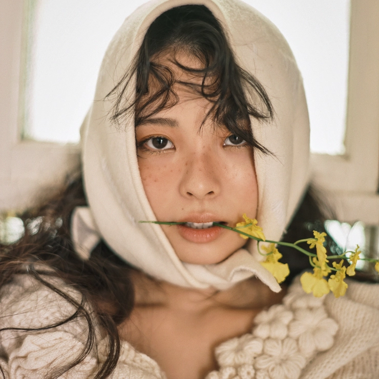 黄色い花をくわえた川口ゆりなさん